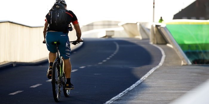 Man bicycling over a bridge