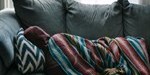 Depression, person sleeping in sofa with a hoodie and blanket