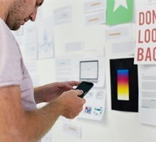 man infront of a collage on wall